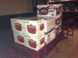 There are numerous cooking pots kept in their original boxes.