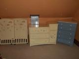Third Floor: A CHILDCRAFT "Legacy" crib (mattress is nearby) with moon, stars and clouds complements a CHILDCRAFT "Legacy" chest with four drawers and one door. To the right is a 5-drawer blue chest with cream color wooden knobs.