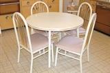 Round white kitchen table with four chairs plus a leaf
