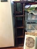 Shelving unit with turned spindles, and several window air conditioners.