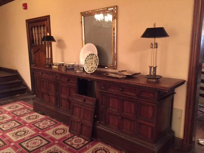 Very long Sideboard with miscellaneous items and a vintage mirrored frame.