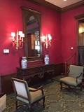 Mirrors (1 of 2), heavily carved consoles (1 of 2), custom brass sconces (2 of 8 available), pair of French Provincial Chairs.