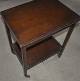 Wooden two-tiered cart on wheels.  Top opens and twists so that it doubles in size.