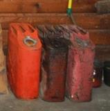 Three old large metal gas cans.