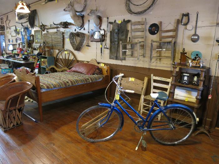 Nice 3/4 Size Bed With Custom Made Mattress, Vintage Rango Bicycle, Shotgun Chaps, Notice The Large Spool Shelf Behind The Bicycle.  