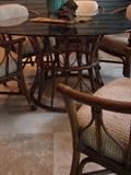 Rattan table with glass top and six chairs on casters