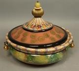 Lot 7:  MACKENZIE CHILDS Ceramic Lidded Tureen. "Piece de Resistance".  Retails for $650. From their website: C’est merveilleux. An exquisite showcase of our master artisans’ skills, the Pièce de Résistance Lidded Tureen is truly a magnum opus. Crafted from clay, the tureen is hand-painted with a spectrum of designs featuring faux marbling, vivid striping, and ceramic floral transfers, embellished with gold and platinum lustres. The sweeping curve of the lid is crowned with a handsome knob of bone disc, crimped brass, and stone beads. A centerpiece that will draw a crowd. Look for the artisans’ marks on the underside of this work of art. 128 oz capacity.: Dimensions:  H: 10.75 inches: W: 12.75 inches: D: 12.75 inches --- US Shipping charge: $50