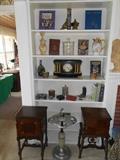 Living Room:  The bookcase on the left displays a mantel clock and various decorative items including several smoking-related items.  In the foreground are two vintage smoking stand tables which are copper lined.  In the middle is a vintage silver and slag glass smoking stand.  