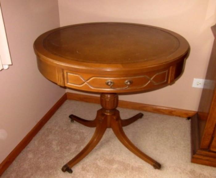 Vintage round pedestal table by Mersman.  Walnut, one drawer, leather-look top, Duncan Phyfe style base on wheels.