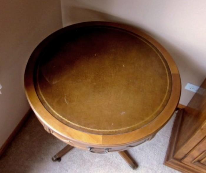 Vintage round pedestal table by Mersman.  Walnut, one drawer, leather-look top, Duncan Phyfe style base on wheels.
