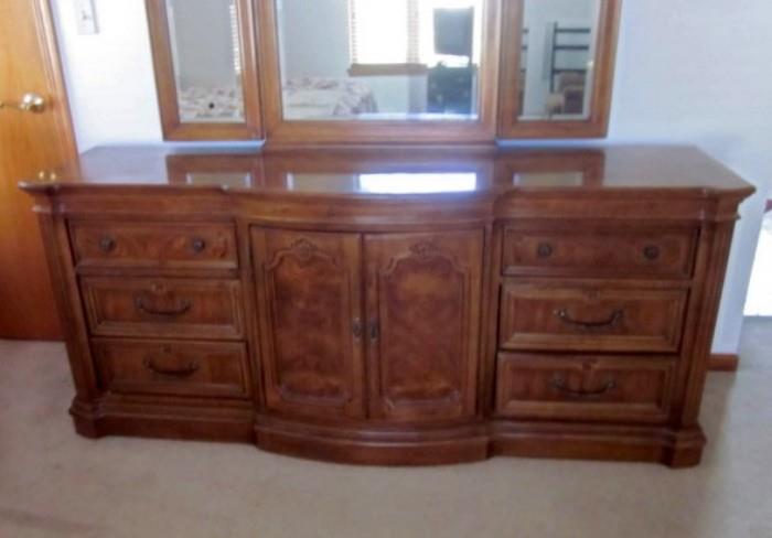 Triple dresser with Burlwood veneer, 6 drawers plus 3 additional drawers behind double doors, brass hardware, 3-section beveled mirror with adjustable sides.