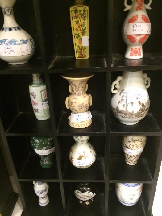 Collection of miniature vases in display cabinet