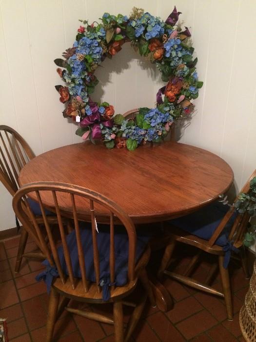 Round oak table, 4 chairs, and large wreath