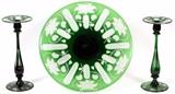 Lot#1024, LIBBEY EMERALD TO CLEAR GLASS CENTERPIECE & PAIR OF CANDLESTICKS, H 2 1/4"-14 1/8", DIA 18 1/2"Including a centerpiece bowl having a flat basin of ombré emerald green, with a clear to emerald etched water lily and lily pad motif alternating among panel flutes.  Together with two single light candlestick holders of the same emerald overlay and motif.  Marked at the undersides.  Three items total.