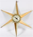 Lot#1106, SUNBURST ELECTRIC WALL CLOCK, MID 20TH C., H 21", W 17"Having six ray arms and a cream and gold tone clock face.  Measuring H.20 1/4" x W.17".