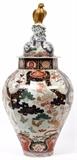 Lot#1126, JAPANESE IMARI PORCELAIN OCTAGONAL JAR WITH COVER, EDO PERIOD, H 30'', DIA 12"Octagonal shape with conforming cover centered by a gilded hawk finial perched on rockwork; decorated in underglaze blue and polychrome enamels with a scene of phoenix and trees, the shoulder and foot painted with lappet patterns enclosing cranes, plants and rabbits.  No apparent markings.  Edo period (1615-1868), probably circa 1700.