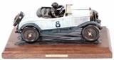 Lot#1, ALEXANDER BUCHAN BRONZE SCULPTURE, H 6", L 14.25", "SETTING THE PACE"Alexander Buchan [American, 20th C.].  A bronze sculpture of a driver in a race car.  Signed on the base, numbered edition 8/15 with a copyright date of 2001.  On a wood base H 2", L 17.5", D9".