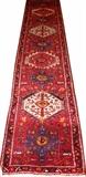 Lot#51, HERIZ DESIGN HAND WOVEN WOOL RUNNER, W 2' 7", L 5' 6"Having three borders, red field with four medallions with geometric designs in navy, ivory, pink, orange and light blue.