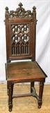 Lot#129, CATHEDRAL STYLE HAND CARVED OAK CHAIR, H 46"English made with a carved and pierced crest with three finials. Pierced back rest with traditional gothic shapes. Wood seat, with turned and tapered legs with stretchers.
