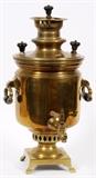 Lot#144, RUSSIAN BRASS SAMOVAR, C1878, H 20", W 11", D 12"Russian Brass samovar. Round lid with two turned black wood handles/finials Two brass hanging handles with turned black wood grips. Mounted on a square footed base with numerous engraved inscriptions and Cyrillic seals one dated 1878 .