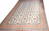 Lot#135, INDIAN DHURRIE, HAND WOVEN WOOL RUG, W 9', L 12'having a flat weave, beige ground, three borders with the primary border in beige with a red/orange meander design flanked by two sea foam green guard borders. The field is populated with seafoam green meandering lines with matching red/orange accents with blue tips.