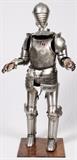 Lot#2218, MACKENIE-SMITH, SHEET METAL & FABRIC REPRODUCTION LIFE SIZE SUIT OF ARMOR, H 74"Later 20th c.; custom made by MacKenie-Smith, Truckee, CA 96160 with their Latin cross hallmarks; with stand; no sword but complete otherwise including an additional helmet 