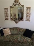 green/tan sofa, decorative pillows, and wall decor