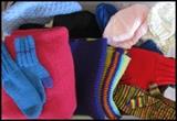 Hand-crafted knit items including several newborn baby hats.