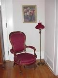 Victorian arm chair on casters, floor lamp with quilted glass shade, framed floral print