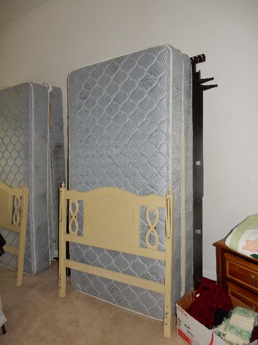 pair of twin beds with headboards  along with matching dressers and mirrror
