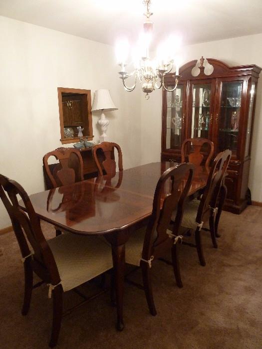 Dining room table and Bassett china cabinet. Chairs with plastic protection and covers.