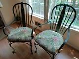 Pair of distressed green metal frame chairs with floral upholstered seats