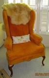 Second of two groovy orange chairs, shown with sheepskin throw