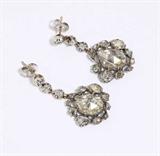 Lot# 1028 A pair of antique diamond earrings 









Circa 1850, silver, each suspending a backed pear-shaped rose-cut diamond measuring 11 x 8 mm and 10 x 8.5 mm, surrounded by 26 rose-cut diamonds, 1'' long, later post back fitments and collet diamond links. est:$1800/2250