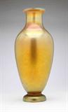 Lot# 1050 A large gold Favrile glass vase, L.C. Tiffany 









Circa 1900, engraved to underside ''1449M L.C. Tiffany Favrile'', the flared circular rim over a tapering neck and hipped body. 17.25'' H x '' D x 7'' Dia. est:$2000/4000