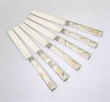 Lot# 1049 A set of six ''Lap Over Edge'' sterling silver and gilt metal-inlaid luncheon knives, Tiffany & Co 









Circa 1890, marked ''Tiffany & Co Sterling'' and ''m 115'', each distinctly decorated, three with flowers and foliage, one with bats, one with a fish, one with a crab, and one with snowflakes, each 8.25'', each monogrammed ''JLH'', 6 pcs. '' H, 13.2 oz troy approximately. est:$1000/1500