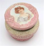 Lot# 1053 A CF Monroe Nakara glass dresser box 









Circa 1900, marked to underside in black ''Nakara / C.F.M. CO.'', rose-to-cream ground with raised scroll and wave decoration, the domed, hinged lid stenciled with a portrait of a brunette beauty, the circular bulbous body with inscription ''Collars and Cuffs'' outlined in white enamel beading, with brass mounts. 6.6'' H x 8'' Dia. est:$500/800