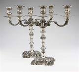 Lot# 1070 A pair of silver Baroque style 3-light candelabra 









Probably mid 20th century, each marked to drip pan with a bird in flight within an oval and 900, each on a domed square anthemia-decorated base rising to a knopped baluster stem issuing two scroll-decorated s-form candle arms and a central light with vase-shaped sockets, anthemia-decorated fluted drip pans and detachable nozzles, convertible to candlesticks, each monogrammed to stem ''PHS'', not weighted, 2 pcs, total gross weight 215.9 oz troy approximately, each. 14'' H x 15.5'' W. est:$2000/3000