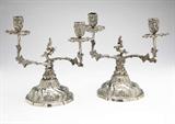 Lot# 1072 A pair of German .800 silver Rococo style two-light candelabra 









Late 19th century, each with makers mark ''ED''(?) conjoined and ''800'', each with a central foliate-sheathed asymmetrical stem issuing two twisting S-form candle arms, on a domed circular foot, 2 pcs, 48.2 oz troy tw approximately, each. 9'' H x 5.5'' Dia. est:$1200/1800