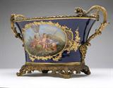 Lot# 1111 A Paris porcelain gilt bronze-mounted jardiniere, Binet 









19th century, signed Binet, with illegible inscription to underside, the cobalt blue ground with reserves decorated with putti engaged in agrarian pursuits, the branch-form handles sheathed with grape clusters and leaves terminating in Bacchic masks, on scrolled feet. 10'' H x 18'' W x 10'' D. est:$1500/2500