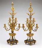 Lot# 1114 A pair of Continental Empire style gilt bronze 6-light candelabra 









Probably first half 20th century, each with six foliate-sheathed candle arms issuing from a central stem surmounted by an acorn finial and decorated with foliate wreaths and acanthus leaves issuing flower sprays, on four ram's-headed hoofed legs, on square wooden bases with toupie feet. 32.25'' H x 10.5'' W x 6.5'' D. est:$1500/2500