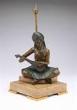 Lot# 1146 A Continental cold-painted and patinated bronze figural table lamp 









Circa 1920, apparently unmarked, depicting a seated woman in Oriental costume playing a stringed instrument, mounted on a stepped square onyx lamp base with an electric lamp fixture, on gilt metal feet, overall. 13.25'' H x 6.5'' W x 6.5'' D. est:$800/1200