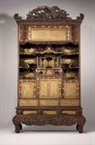 Lot# 1153 A Japanese carved, metal-inlaid and gilt hardwood cabinet 









Meiji period (1868 - 1912), carved throughout with birds, trees, flowers, dragons and foliage, enclosing an arrangement of sliding and hinged doors, open shelves and a miniature temple decorated with landscape scenes and fans, on a dragon-carved base with scrolled supports, overall. 95'' H x 53'' W x 24'' D. est:$6000/9000