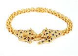 Lot# 1167 A diamond, sapphire and 18K yellow gold panther motif bracelet 









With ruby eyes, the two facing panthers connecting to an oval ring attached to panther links, set with 148 full-cut diamonds totaling approximately 0.85 ct, graded I-J color and SI clarity, 6.75'', 21.1 gms. est:$800/1200