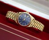 Lot# 1176 A lady's 18K gold Rolex Datejust President wristwatch 









Circular blue dial with date aperture and gold tone baton numeral markers, dial marked ''Rolex Oyster Perpetual DateJust Superlative Chronometer Officially Certified'', fluted bezel, screw-down crown, oyster case, Ref #69178, Serial #8674597, 18K yellow gold Presidential bracelet with 35 links, hallmarked, no. #8570F, circumference: 6.75'', includes Rolex box, wallet, and Rolex Garantie paper. est:$4000/6000