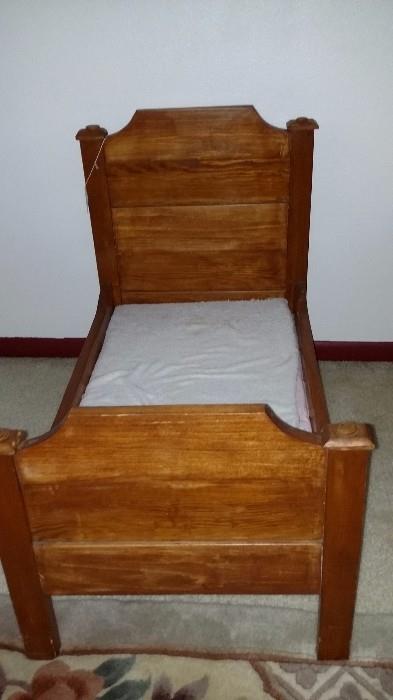 Antique doll bed made of solid wood with a mattress