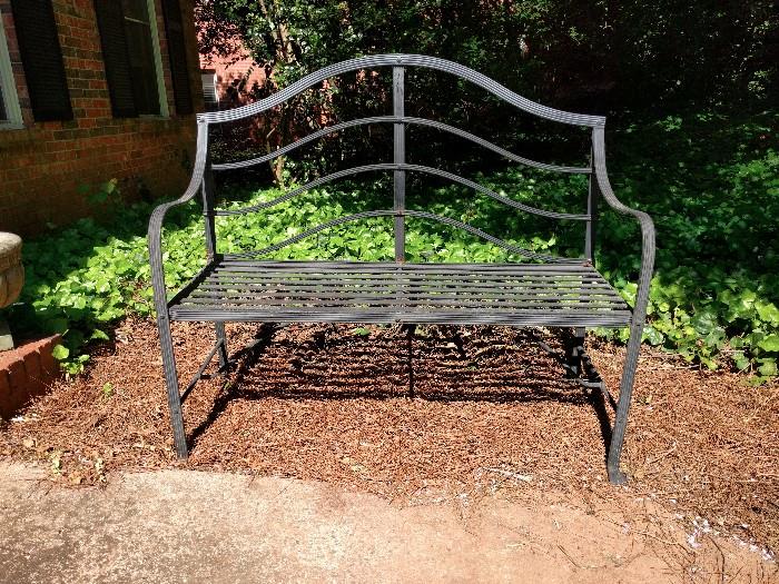 Wrought iron love seat. It works!                                      How do I know? Do YOU see anyone sitting on it?