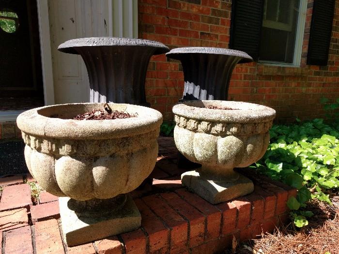 Bulbous, girthy cement planters, ready to be plowed for spring/summer planting.  Looking over their soft shoulders are a pair of poseurs, cast aluminum planters, on a diet to dispel the notion of their overweight cast iron cousins. 