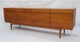 Lot 16:  Ib KOFOD-LARSEN Danish Teak Modernist Credenza Sideboard. Body raised on legs. Four Drawer; four door. Not marked.: Dimensions:  H: 30.25 inches: W: 90.5 inches: D: 19.5 inches --- 