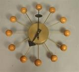 Lot 50:  GEORGE NELSON for HOWARD MILLER Ball Clock. Brass tone case with natural wood balls. Marked: Dimensions:  H: 13.25 inches: W: 13.25 inches: D: 2.5 inches --- US Shipping charge: $35